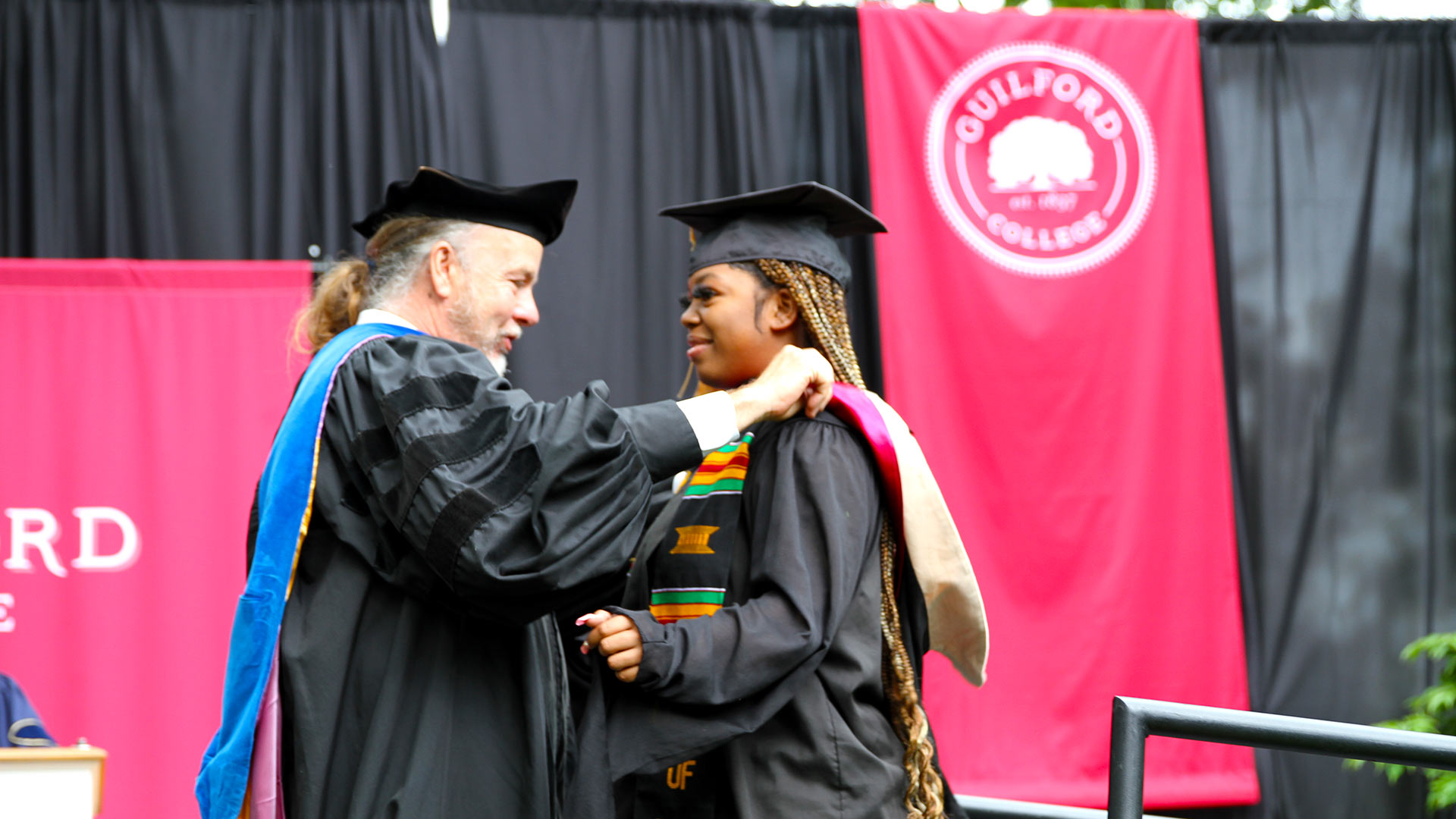 Will Pizio bestows a hood on Masters Graduate Terraia LaChe’ Davis '23