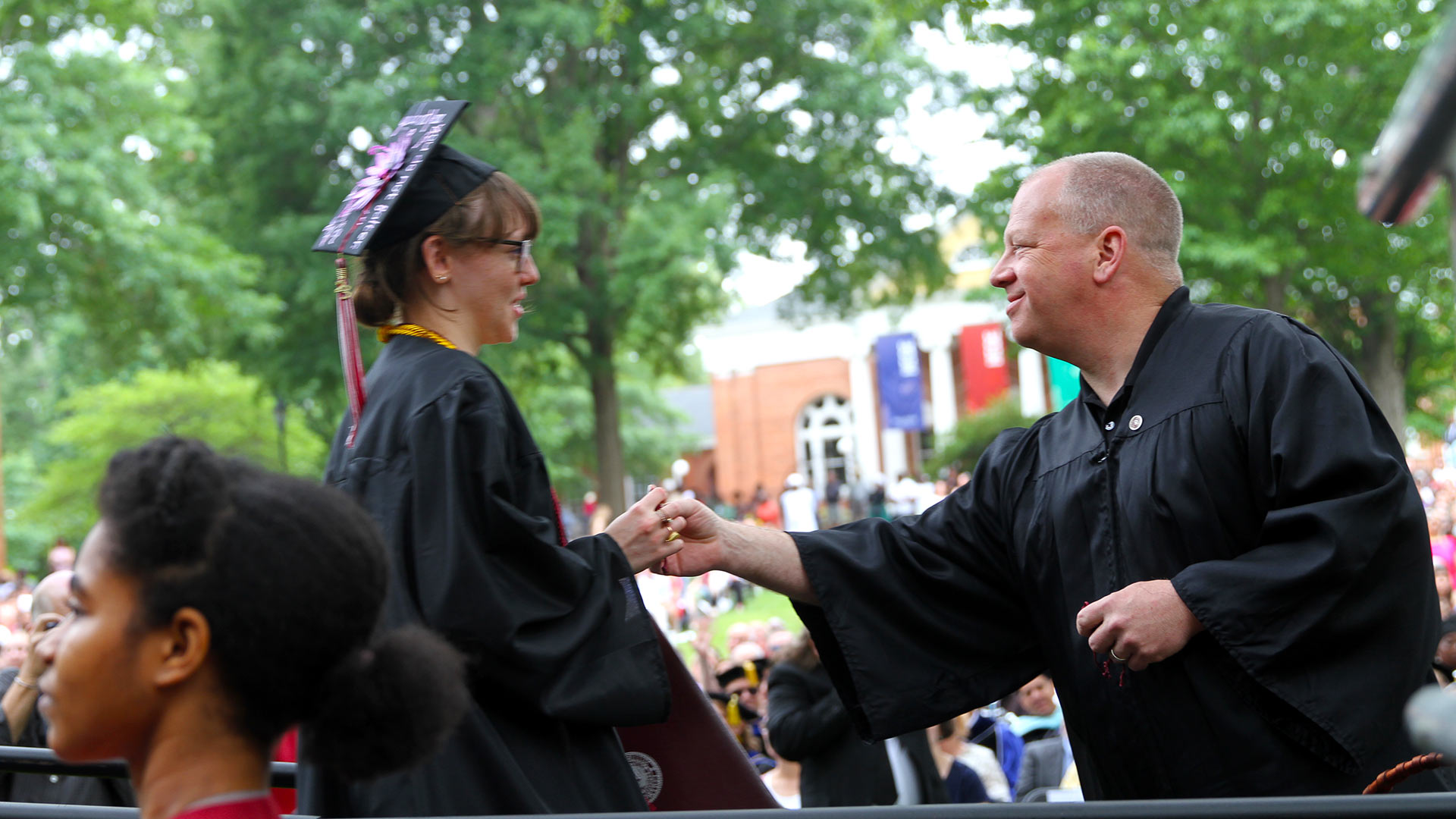 Mark Edwards '90 hands Diyaa Kaufman '23 an Alumni pin