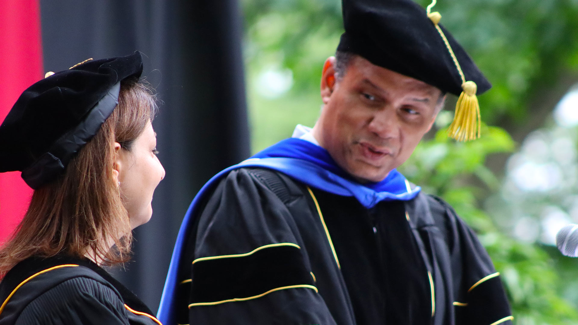 Kyle Farmbry addresses Mandy Cohen as he bestows an Honorary Doctorate from the College