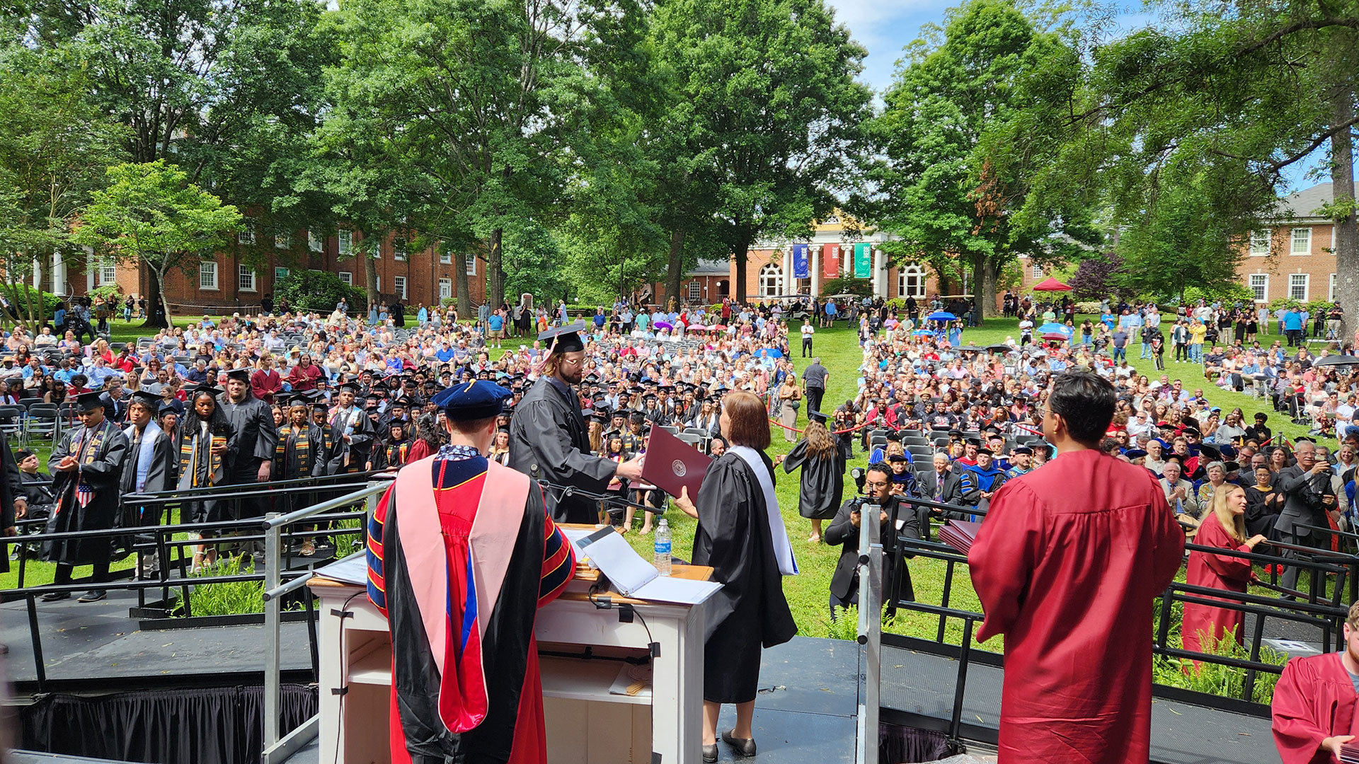 Receiving diploma covers on the Commencement stage