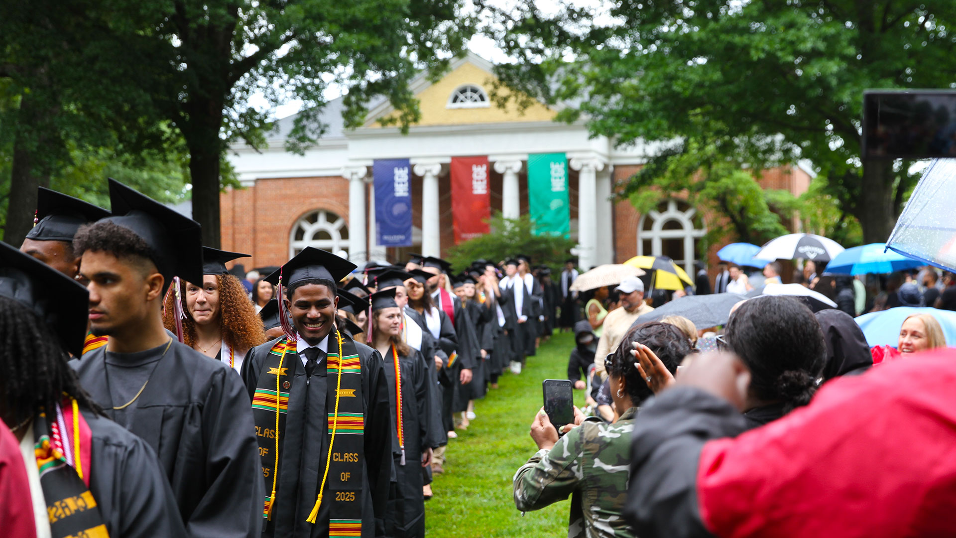 Graduates process through the Academic Quad to bagpipe music