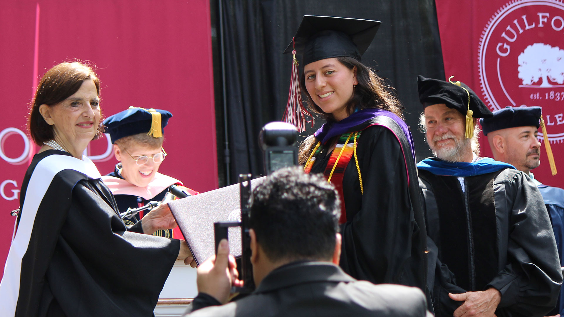 Master's graduates were hooded by their professors before receiving their diploma covers