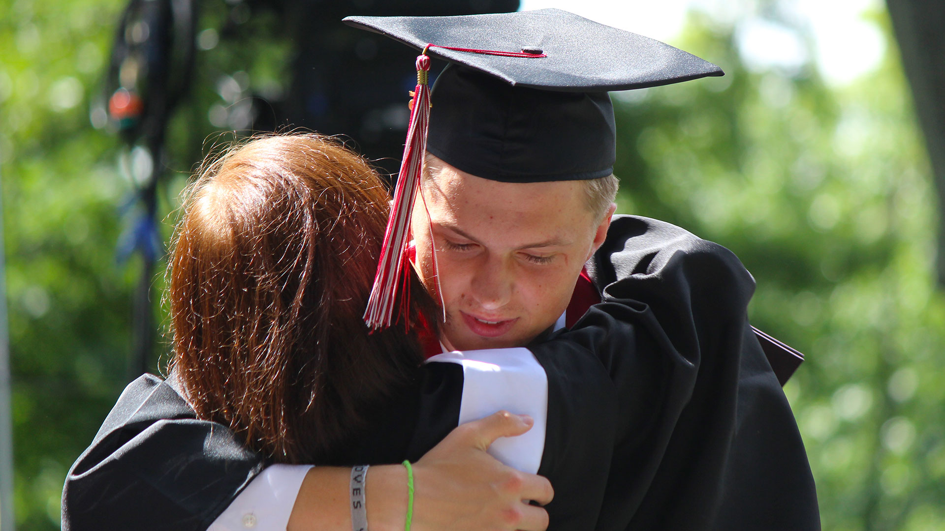 Student Body President Jacob Mitchell '25 hugs Acting President Jean Bordewich on the Commencement stage