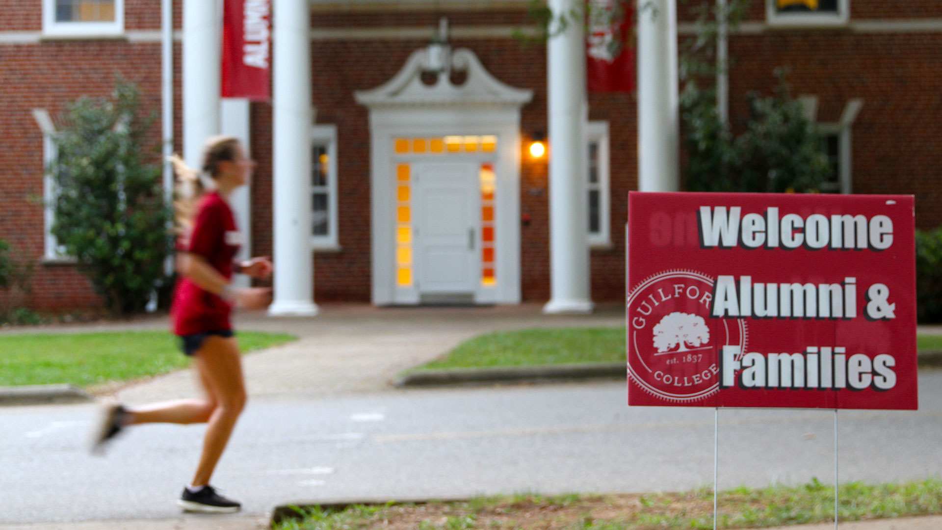 A runner passes in front of Alumni Gym