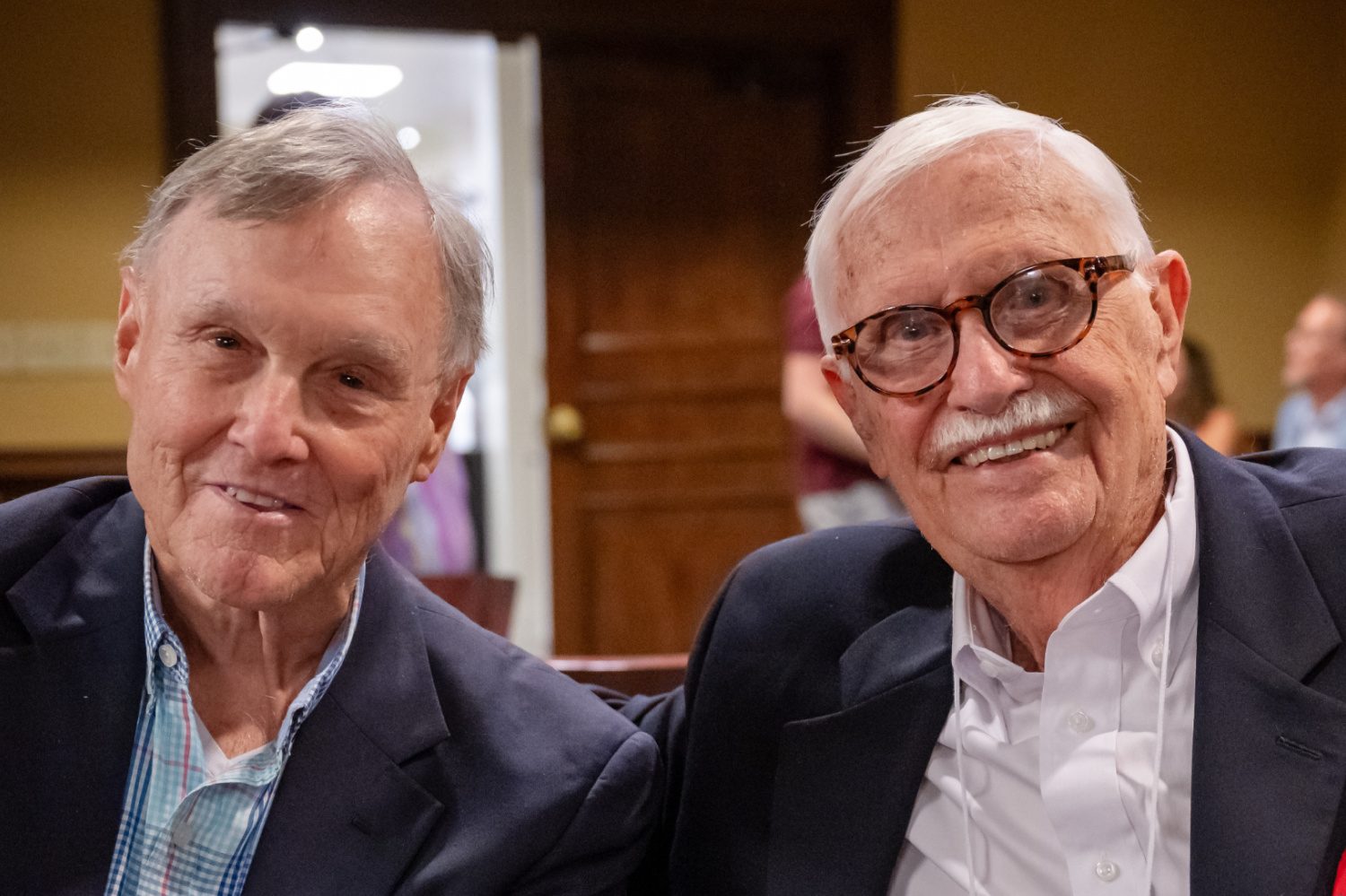 JimSchlosser and Hugh Normile, '65 classmates, catch up in the Gilmore Room.