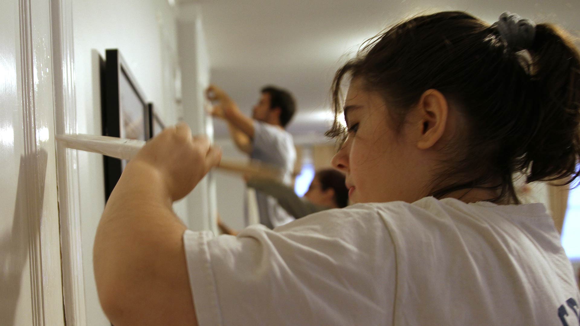 Students paint trim inside a building at Muir's Chapel on Day of Service.