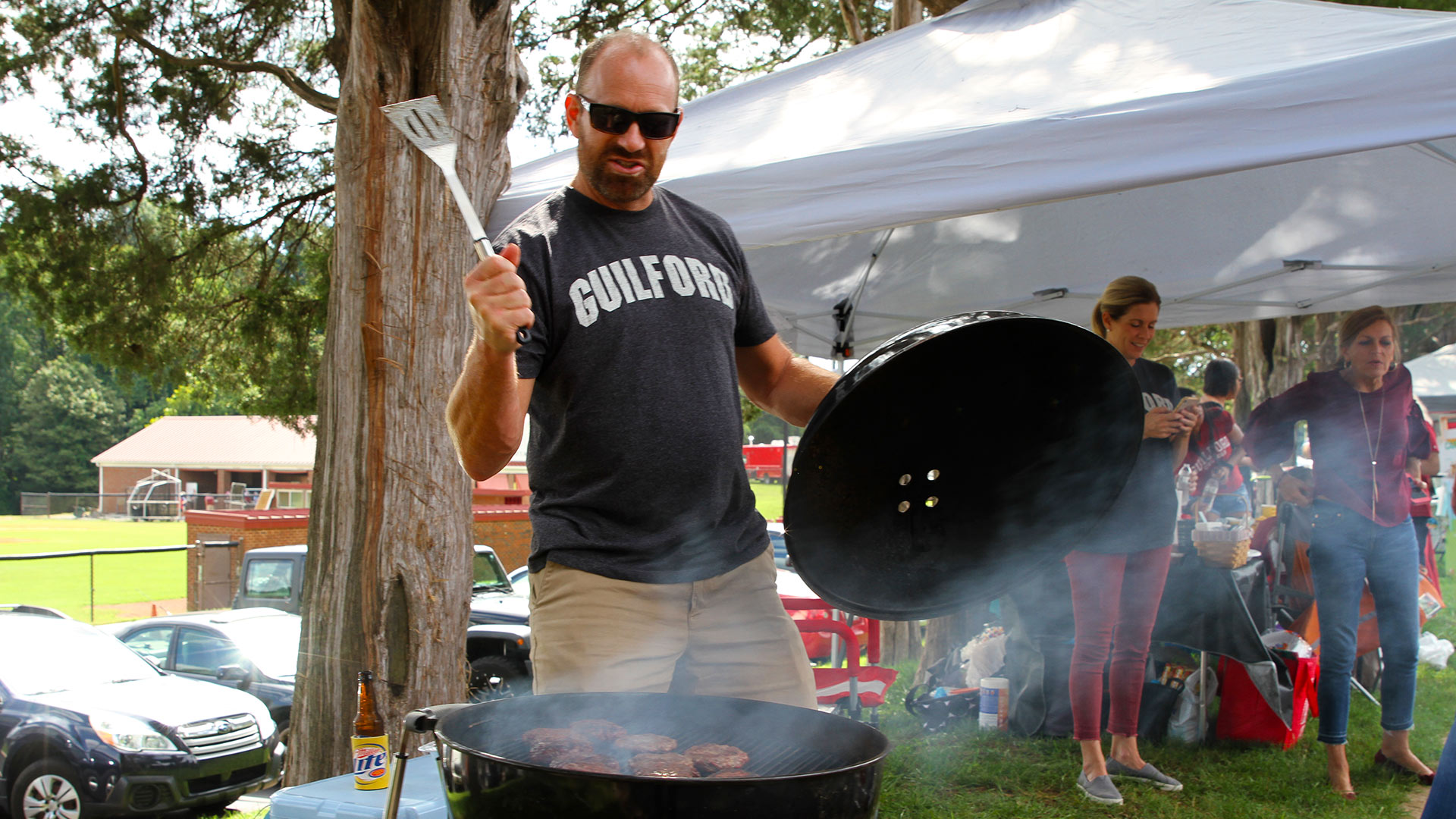 A Guilfordian cooks delicious food on the grill during tailgating at Homecoming.