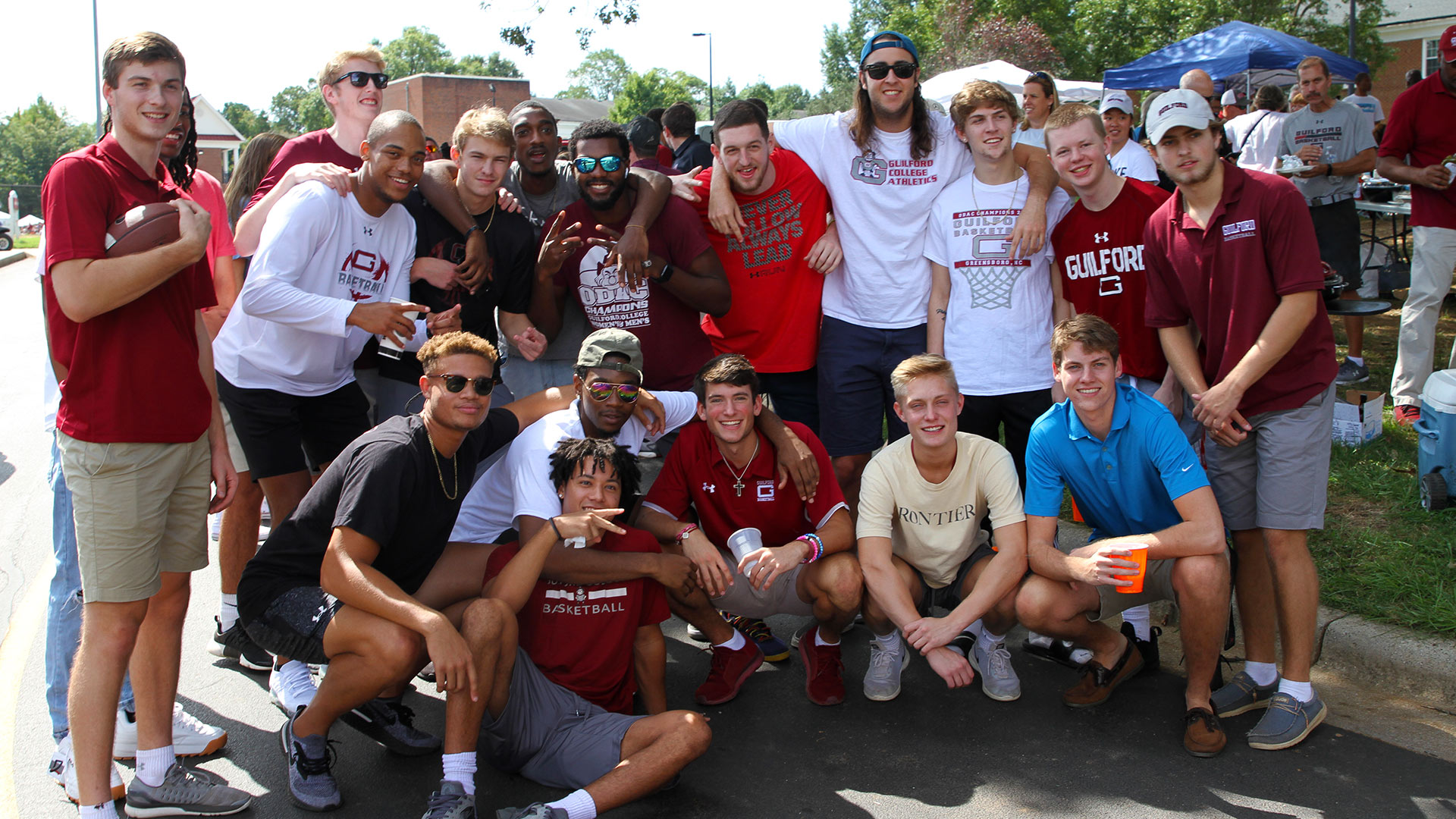 A large group of Guilford students athletes pose for a photo at Homecoming.