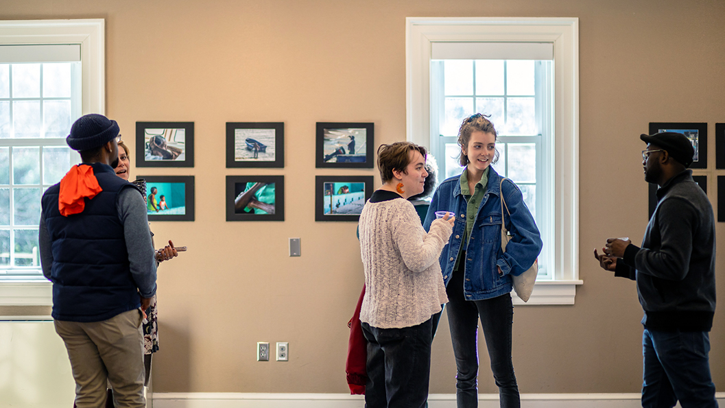 Viewers discuss works of art at the "When The See Us" exhibit.