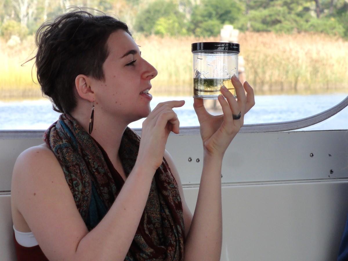 A student in the Cape Fear River Basin Studies Program studies a water sample on a day trip to Wilmington, N.C.