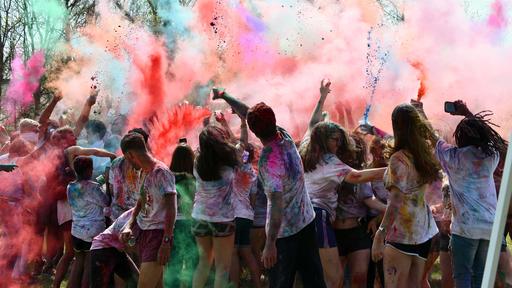 Guilford College students participate in the annual Serendipity colorfest, throwing colored powder into the air. 