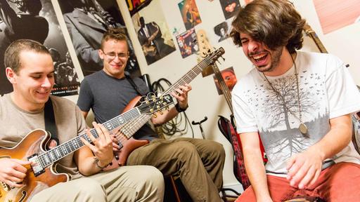 Guilford College students participate in a jam session with guitars and drums. 