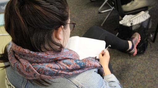 A student takes notes in class.