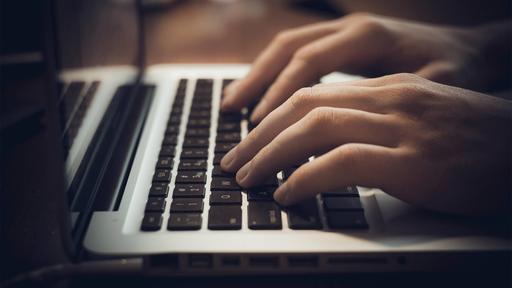 Hands typing on a laptop.