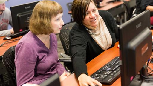 Adult students work in a computer lab.