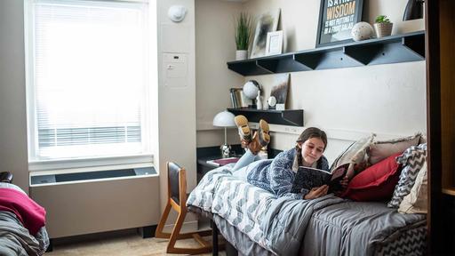 A Guilford College student reads in a room in Binford Hall. 