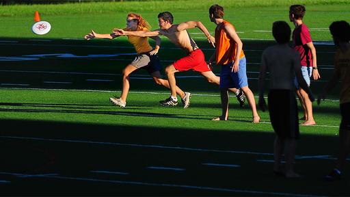 Students play Ultimate Frisbee in a field.