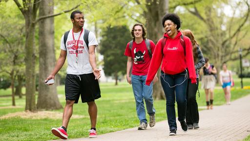 Three Guilford College students walk through the Quad.