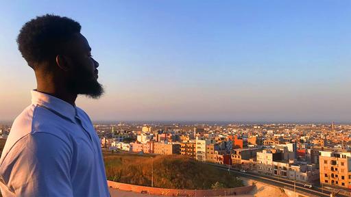 Guilford student Khassir Atchabao '20 looks over the city of Senegal in the evening.