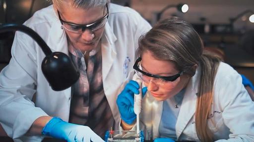 Guilford College student Darby Kozan adds solution to a petri dish with the help of Professor Melanie Lee-Brown. 