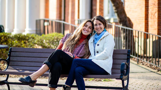 Mallory Cerkleski and Professor Bronwyn Tucker sit on a bench by Hege Library.