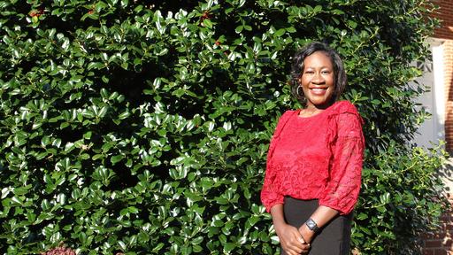 Guilford Transfer Admission Counselor Whitney Kornegay Smith stands in front of New Garden Hall.