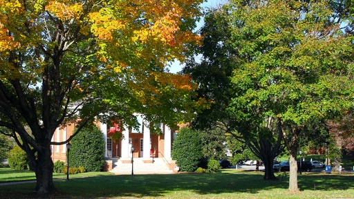 New Garden Hall is seen through the changing leaves in the fall.