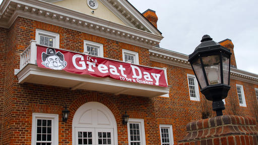Banner saying "It's a Great Day to be a Quaker" hangs on the front of Guilford's Founders Hall.