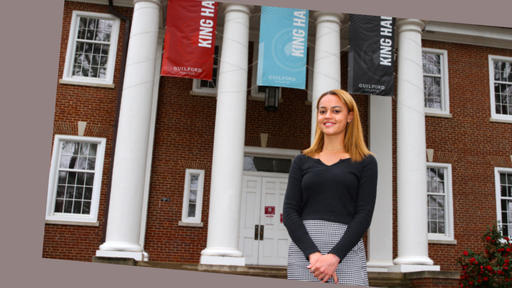 Guilford College student Bea Niyibizi '22 stands outside in front of King Hall.