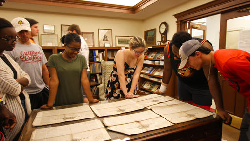 A group of students reviews documents in the Quaker and Special Collections.