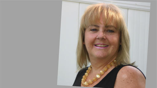 Lisa Demers wearing a black sleeveless top and a necklace with large yellow beads