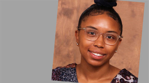 Paris White with her hair in a bun, wearing glasse, and a multicolor top