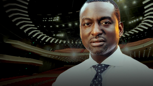 Image of Yusef Salaam wearing a white dress shirt and blue tie over an image of the new Tanger Center auditorium.