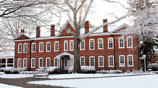 A light snow covers the roof of Archdale Hall, as well as the bushes and tree branches that surround it, while the walkways remain ready for students.
