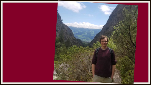 Caleb Bausman stands outdoors in the mountains in Austria, wearing a backpack.