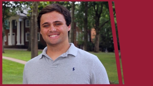 Brooks Stemple stands outdoors on Guilford's Quad, wearing a short sleeve gray polo.