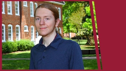 Caleb Huppert stands outdoors near Archdale Hall wearing a navy blue polo shirt.