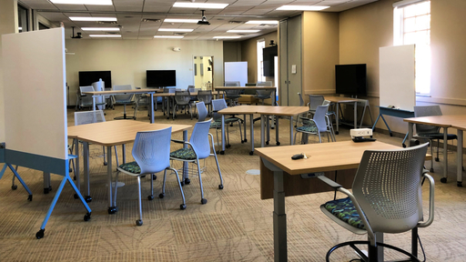 The completed collaboratory is shown, filled with tables, screens, and white boards.