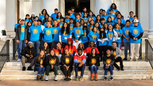 Students wearing blue Soy un Lider shirts take a group photo with Guilford students who organized the 2022 event on the steps of Dana Auditorium.
