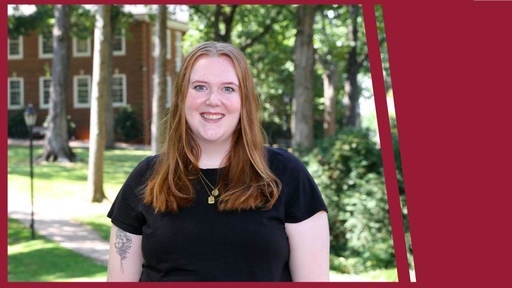 Taylor Calloway stands outdoors on Guilford's Quad, wearing a black t-shirt.