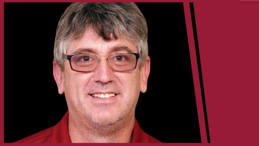 Photo of Jon Bohland wearing glasses and a red polo shirt.