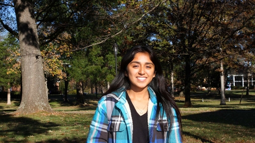 Aileen Cerda on the campus quad in a teal flannel shirt.