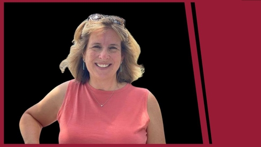 Ann Flynt in a pink top in front of a black background