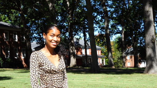Ky'Lexius Gwynn stands outdoors on Guilford's Quad, wearing a leopard-print top.
