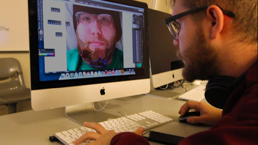 A student prepares a digital rendering of his face in Graphic Design Class