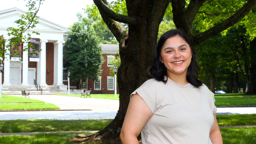 Alejandra Garcia '23 in a tan shirt in front of Dana Auditorium