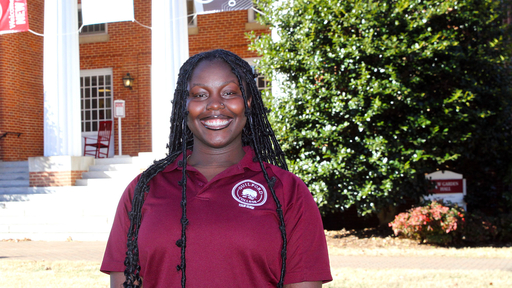 Noelle Syrigos McGinn in front of New Garden Hall, wearing a burgundy polo