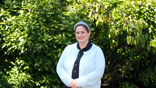 Lori Breighner in a light blue sweater, standing outside New Garden Hall