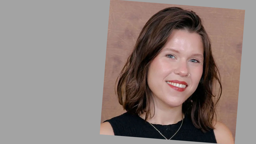 Sam Roth in a black top posing in front of a tan background