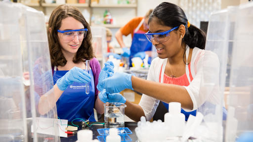 Two students work on a Chemistry experiment.